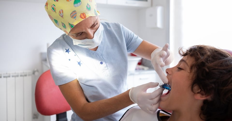 dentist fitting orthodontic plate